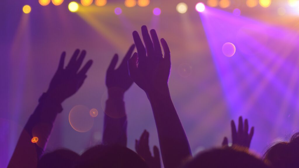 Image of hands raised in praise to God at a church during a revelators conference, representing client work in the NC project portfolio